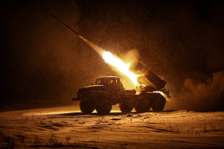 A imagem mostra um veículo militar de grande porte, possivelmente um caminhão, lançando um míssil em um ambiente noturno. A cena é iluminada pela chama e pela fumaça geradas pelo lançamento, enquanto a neve cobre o solo ao redor. O fundo é escuro, destacando a ação do lançamento.