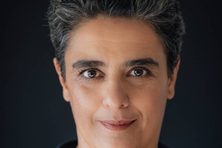 Retrato da colunista Sylvia Colombo; ela tem cabelo curto, levemente grisalho, e sorri com a boca cerrada