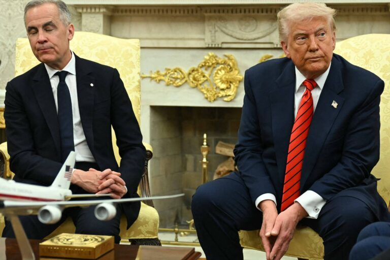 A imagem mostra duas pessoas sentadas em cadeiras em um ambiente formal, possivelmente no Salão Oval da Casa Branca. À esquerda, um homem com cabelo curto e terno escuro parece pensativo, enquanto à direita, um homem com cabelo loiro e terno escuro com uma gravata vermelha parece estar em uma posição mais rígida. Entre eles, há um pequeno modelo de avião em uma mesa. O fundo é decorado com detalhes em dourado e uma lareira.