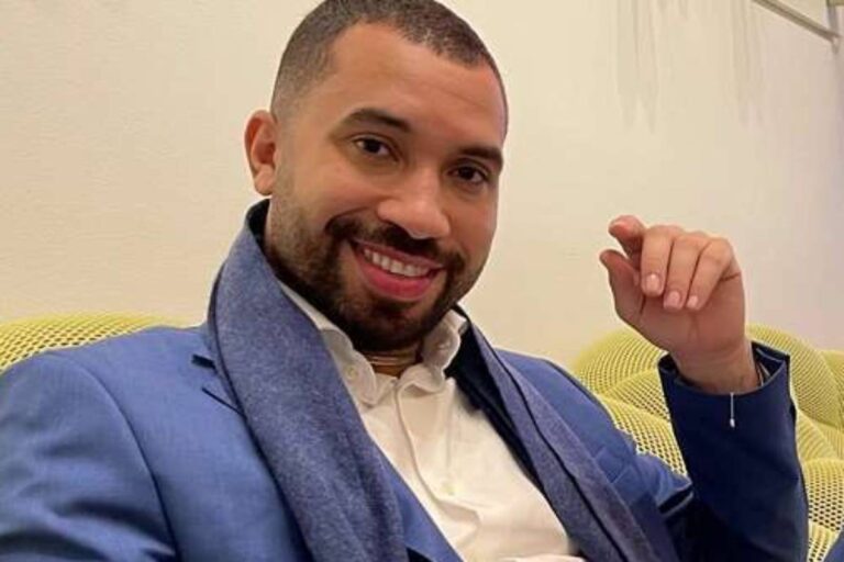 gil do vigor sorrindo de terno azul sentado em sofá no hotel em são franscisco